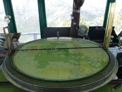 The map and sighting tool used to triangulate the exact position of any fire that's spotted. Note their cooking stove in the background.