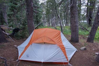 Fortunately we find an area of well used tent pads in a cluster of trees dense enough to keep us reasonably dry as we setup the tent. It's a great spot right near the shore of the lake, which you can see through the trees in the background.