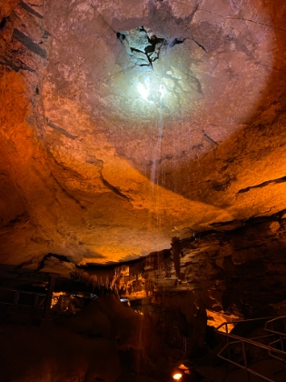 A waterfall flowing through a hole in the ceiling. The sandstone cap gets thinner in this area, allowing water to seep through.