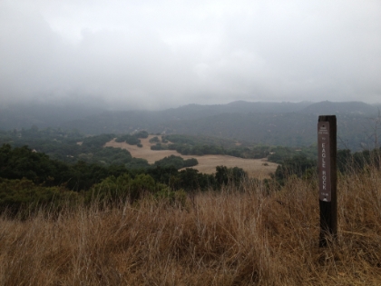 Top of the Santa Ynez trail looking down towards Trippet Ranch on a foggy day.